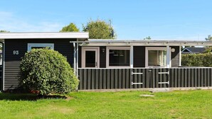 A mobile home with a number "93" on the side, a small porch, and a well-maintained lawn. - 6 Person Holiday Home in Hadsund (Hadsund)