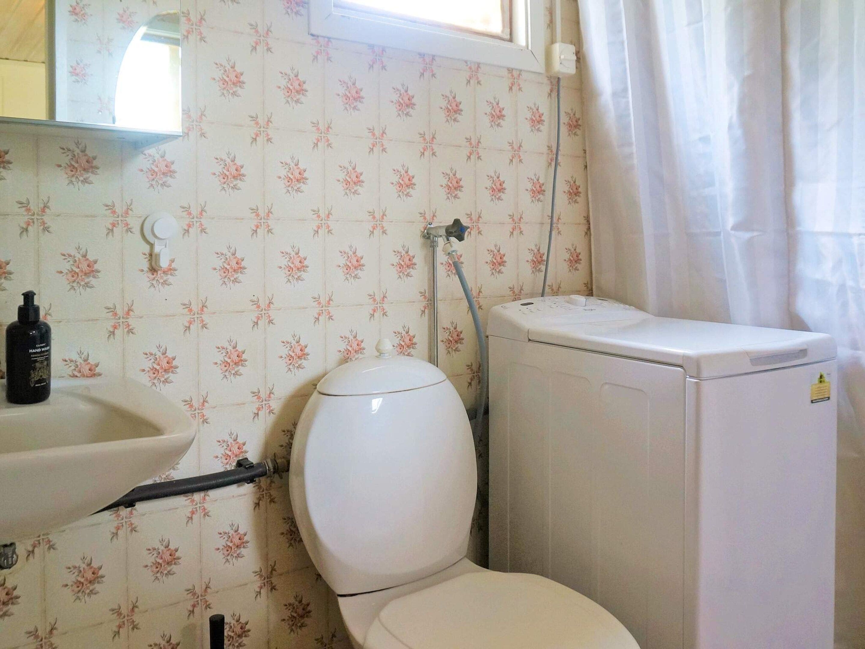 Ein Badezimmer mit Toilette, Waschbecken und Waschmaschine.