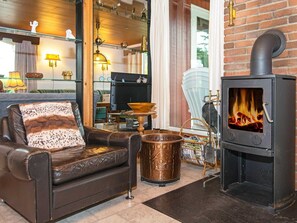 Un salon chaleureux avec un canapé en cuir, une cheminée et une table basse.