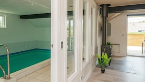 A modern indoor swimming pool with a clear view of the adjacent room. - Elegant Holiday Home in Jutland With Sauna (Horsens)