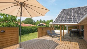 A wooden deck with a pergola, outdoor seating, and a covered area with a table and chairs. - Elegant Holiday Home in Jutland With Sauna (Horsens)