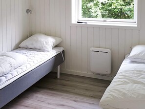 A room with two single beds, a window with a view of greenery, and a white radiator. - 5 Star Holiday Home in Sydals (Sydals)