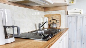 A kitchen with a wooden countertop, stainless steel sink, and a kettle. - 4 Person Holiday Home in Arjang (Årjäng)