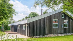 A modern building with a sloped roof, a chimney, and multiple windows. - 6 Person Holiday Home in Hadsund (Hadsund)