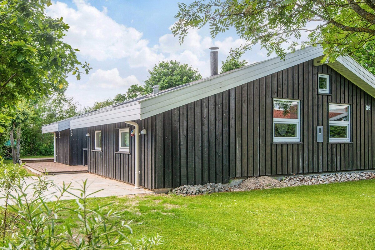 A modern building with a sloped roof, a chimney, and a small window.