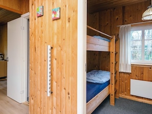 A wooden interior with a bunk bed, a white refrigerator, and a window with a view of trees. - 4 Person Holiday Home in Ansager (Ansager)