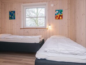 A room with two beds, a window, and two paintings on the walls. - 4 Star Holiday Home in Oksbol (Oksbol)