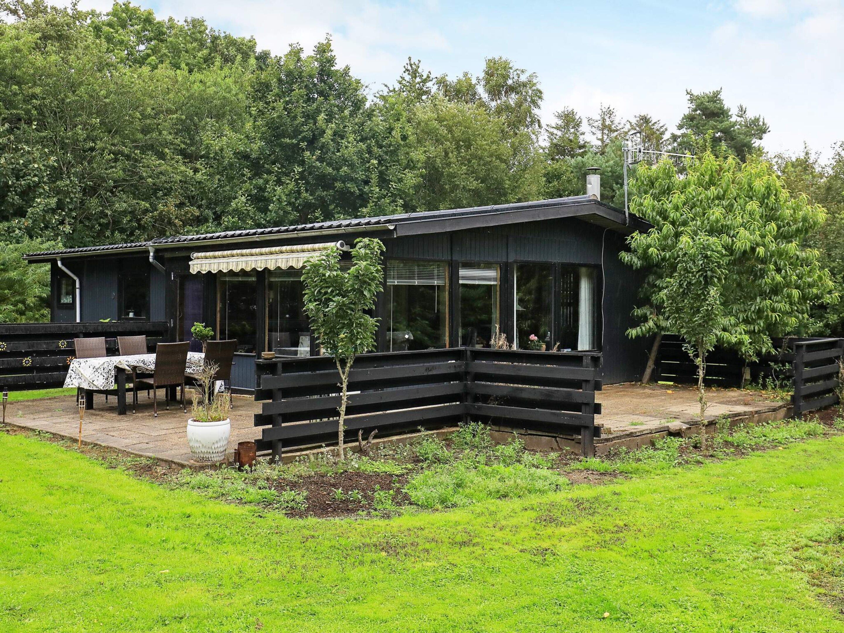 A modern house with a patio, outdoor seating, and a garden.