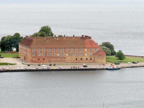 A large brick building with a flat roof, situated by a body of water.