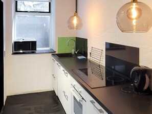 A compact kitchen with a microwave, sink, and stove. - 4 Person Holiday Home in Sonderborg (Sønderborg)