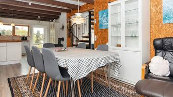 Un comedor con mantel a cuadros, sillas de madera y una alfombra estampada.
