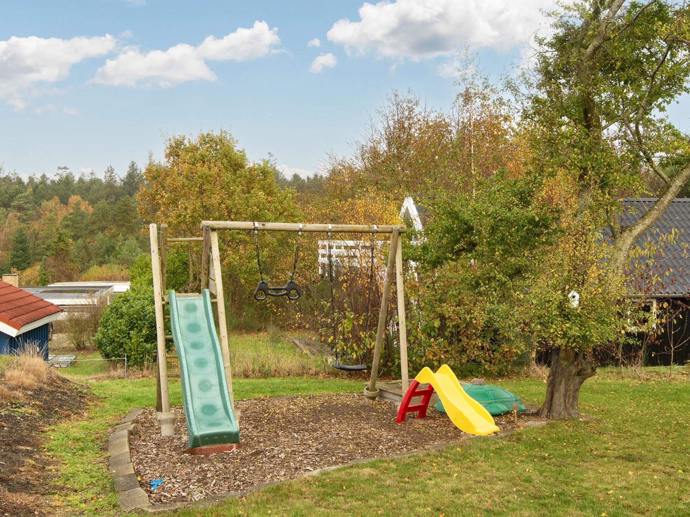 A playground with a swing set, a slide, and a climbing structure.