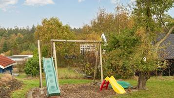 A playground with a swing set, a slide, and a climbing structure.
