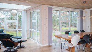 A spacious room with a large dining table, multiple chairs, and a bar area. - 8 Person Holiday Home in Blavand (Blavand)