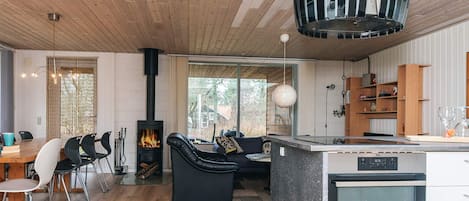 A modern kitchen with a central island, a built-in oven, and a stove.