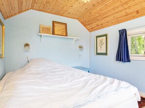A bedroom with a bed, a window with curtains, and wall-mounted light fixtures. - Holiday Home in Snedsted near Sea (Thisted)