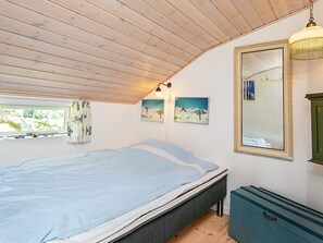 A bedroom with a bed, a window, a mirror, and a dresser. - Holiday Home in Snedsted near Sea (Thisted)