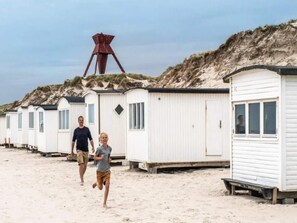 A row of white mobile homes with a sandy beach and dunes in the background. - Seaside Charm Near Blokhus Town-by Traum (Blokhus)