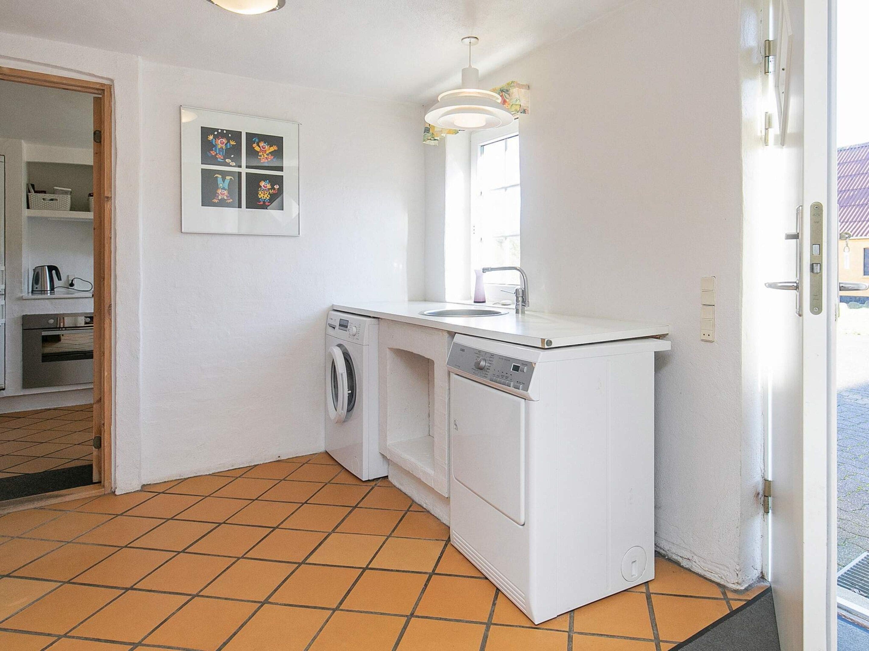 A compact kitchen with a washing machine, dishwasher, and a small sink.