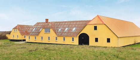 A yellow building with a large arched entrance and multiple windows.