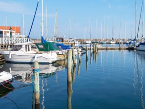 A marina with multiple boats docked, wooden pilings, and a clear sky. - Holiday Home in GrenÃ¥ near Sea (Grenaa)