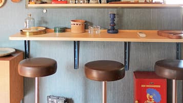 A kitchen with a wooden countertop, stools, and a vintage radio.