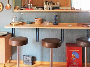 A kitchen with a wooden countertop, stools, and a vintage radio. - 6 Person Holiday Home in Lidkoping (Lidköping)