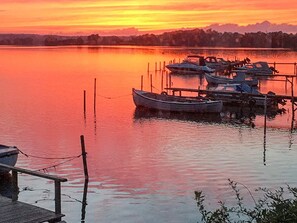 A calm lake at sunset with boats docked at a pier. - 5 Star Holiday Home in Hejls (Hejls)