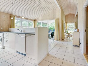 A modern kitchen with a central island, a dining area with a table and chairs, and a kitchen counter with a sink. - 8 Person Holiday Home in Albaek (Aalbaek)