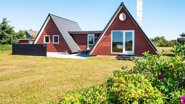 A modern house with a sloped roof, a chimney, and a large window. - 6 Person Holiday Home in Hvide Sande (Hvide Sande)