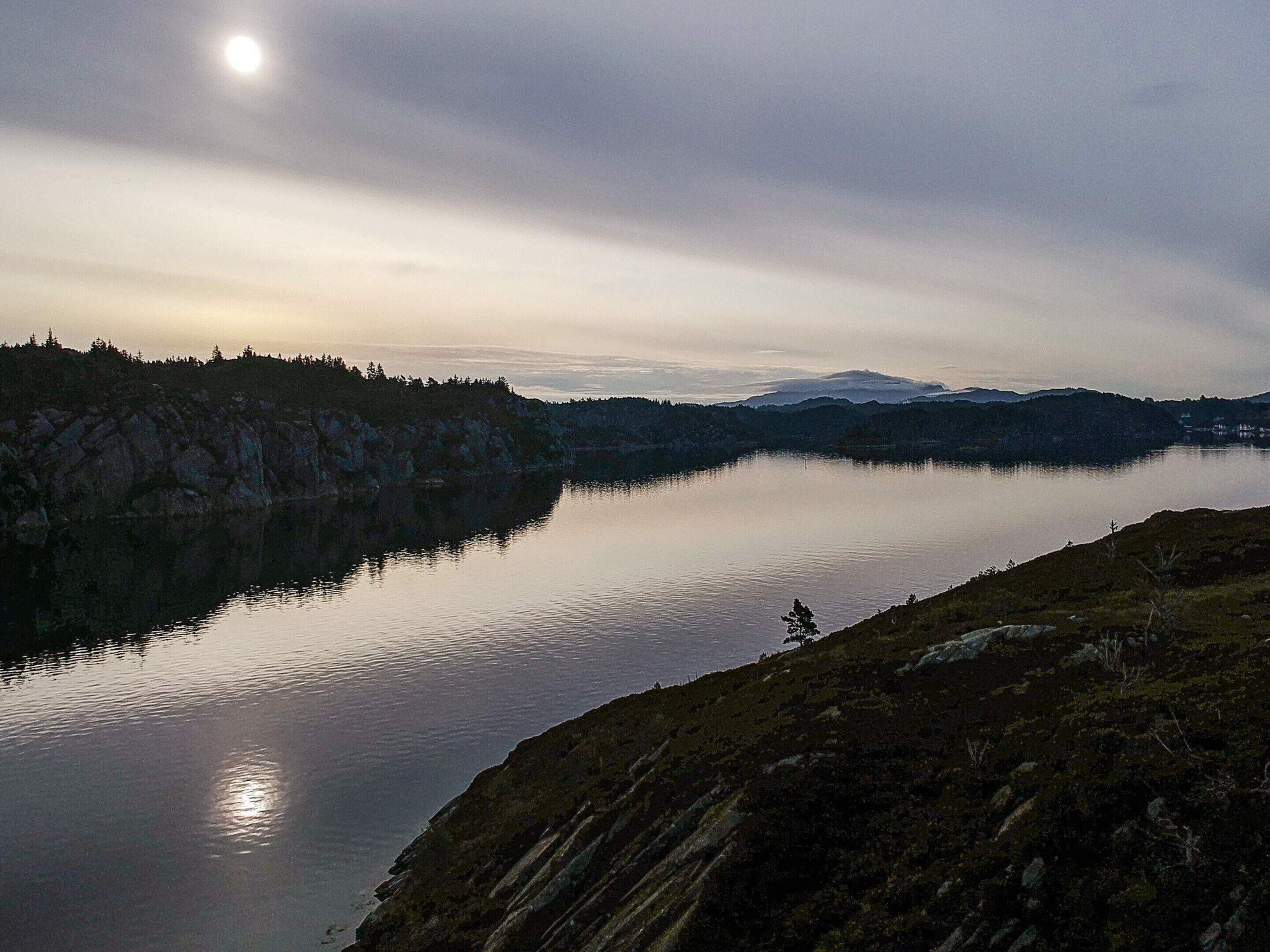 En stilla sjö med ett berg i bakgrunden.