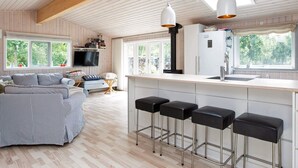 Une cuisine moderne dotée d’un îlot central, de tabourets de bar et d’une grande fenêtre.