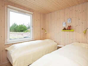 A room with two beds, a window, and a small table.