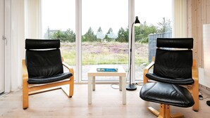Une pièce comprenant deux fauteuils en cuir noir, une petite table et un lampadaire.