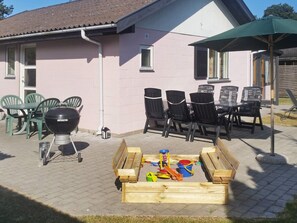 A patio with a grill, chairs, and a table. - 4 Star Holiday Home in Vaeggerlose (Vaeggerlose)