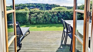 A deck with a view of a green landscape and a body of water. - 6 Person Holiday Home in Lemvig (Lemvig)