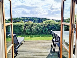 An open deck with a view of a green landscape and a distant body of water. - 6 Person Holiday Home in Lemvig (Lemvig)