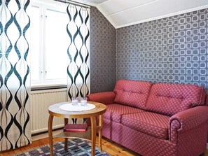 Relax in this inviting living area with a sofa, round table, and patterned rug.