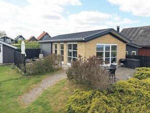 A residential property with a paved driveway, a patio area, and a garden with shrubs. - Cozy Holiday Home in Funen near Sea (Frørup)