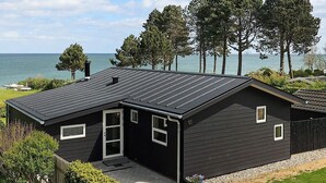 A modern two-story house with a dark exterior, a sloped roof, and a visible chimney. - Cozy Holiday Home in Funen near Sea (Frørup)