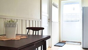 A dining area with a wooden table, a chair, and a potted plant.