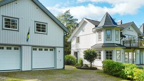 A row of white houses with a garage, a flag, and a tree in the yard. - 6 Person Holiday Home in Lysekil (Lysekil)