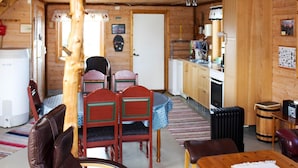 A cozy cabin interior with a dining area, kitchen, and a large wooden beam structure. - 6 Person Holiday Home in Brekstad (Orland)