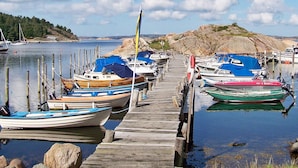 Un muelle de madera con varias embarcaciones amarradas al final.