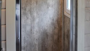 A concrete wall with a metal door frame and a tiled floor.