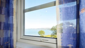 A window with a view of a body of water and trees.
