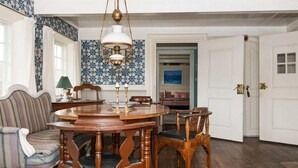 A dining room with a wooden table and chairs, a patterned wall, and a door leading to another room. - 6 Person Holiday Home in Fano (Fano)