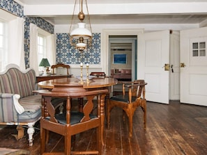A dining area with a round wooden table, chairs, and a hanging light fixture. - 6 Person Holiday Home in Fano (Fano)