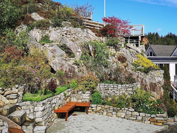 A stone staircase leading up a hill with a wooden bench at the bottom. - 4 Star Holiday Home in Urangsvag (Bomlo)