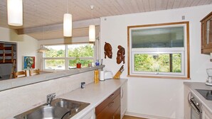 A modern kitchen with a stainless steel sink, wooden cabinets, and pendant lights. - 6 Person Holiday Home in Skjern (Skjern)